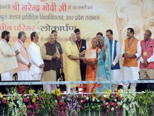 प्रधानमंत्री जी 20 जून, 2017 को ए०के०टी०यू०, लखनऊ में प्रधानमंत्री आवास योजनाग्रामीण की लाभार्थी को आवास का स्वीकृति पत्र प्रदान करते हुए।