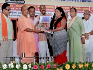 उत्तर प्रदेश के मुख्यमंत्री योगी आदित्यनाथ जी 22 सितम्बर, 2018 को जनपद गोरखपुर में एक महिला लाभार्थी को आवास की प्रतीकात्मक चाभी प्रदान करते हुए। 